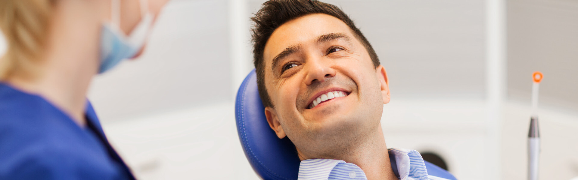 Male patient smiling with dental assistant