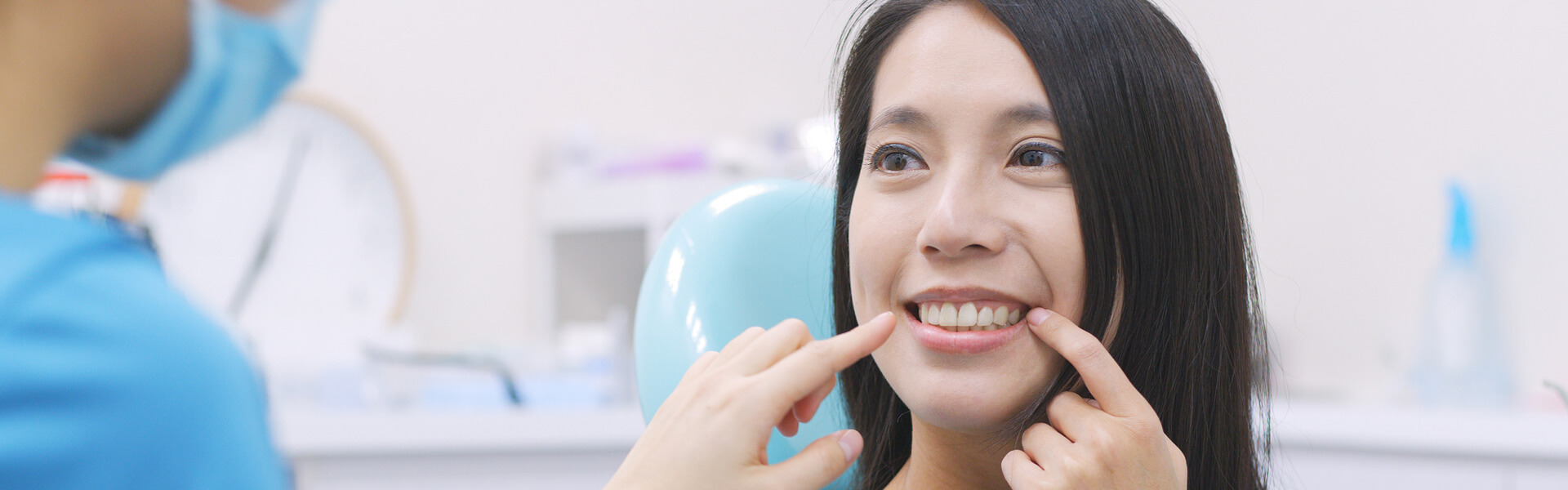 Female patient at dental clinic pointing at her implant tooth